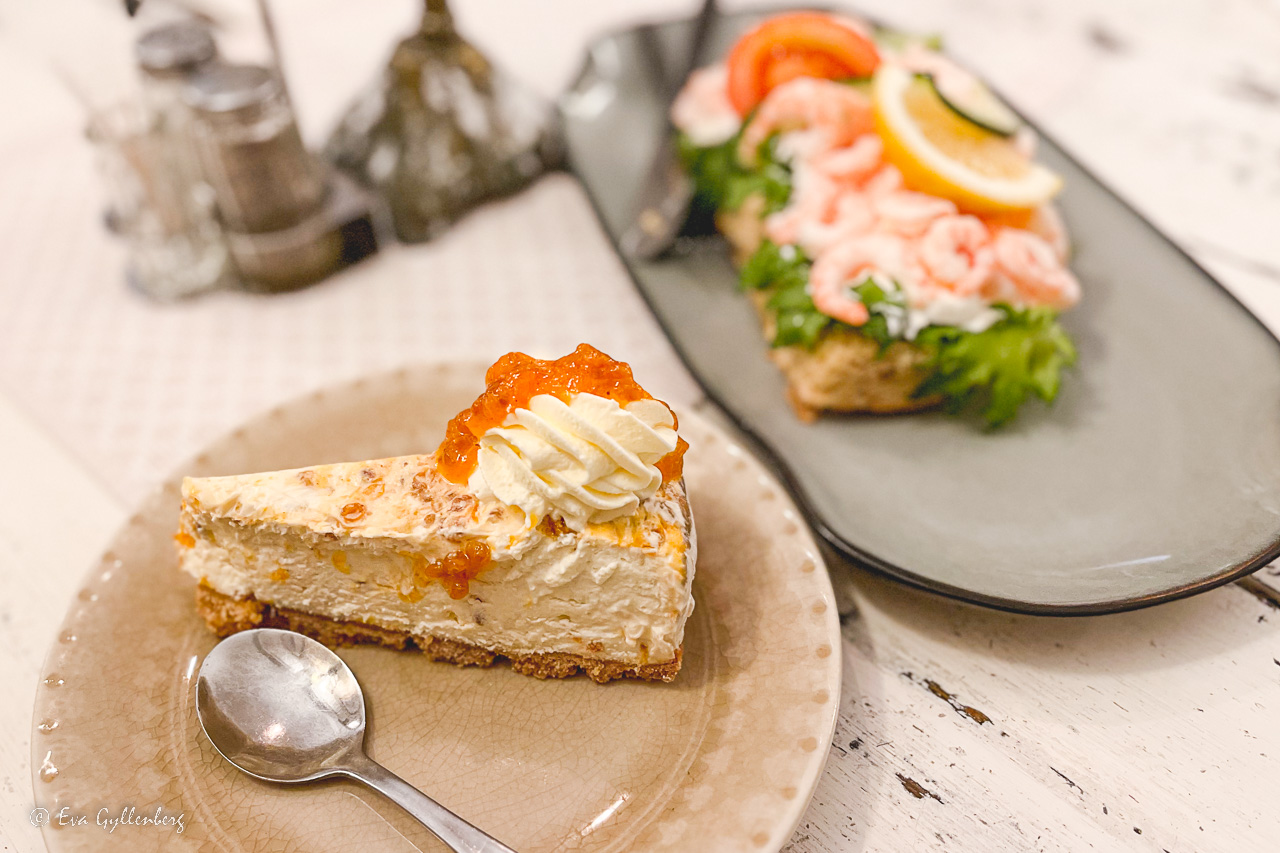 Halloncheesecake på en tallrik och räkmacka på en tallrik - en av alla caféer utanför Stockholm