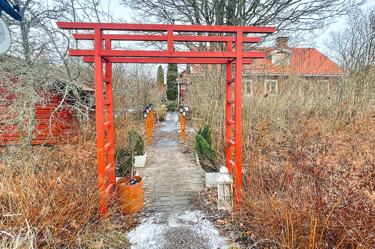 Japanska röda portar i en svensk trädgård