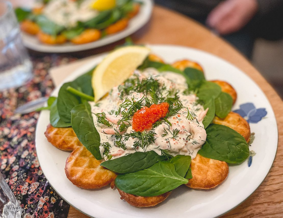 Waffle with shrimp salad and rum on a plate