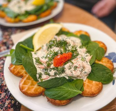 Våffla med räksallad och rom på en tallrik