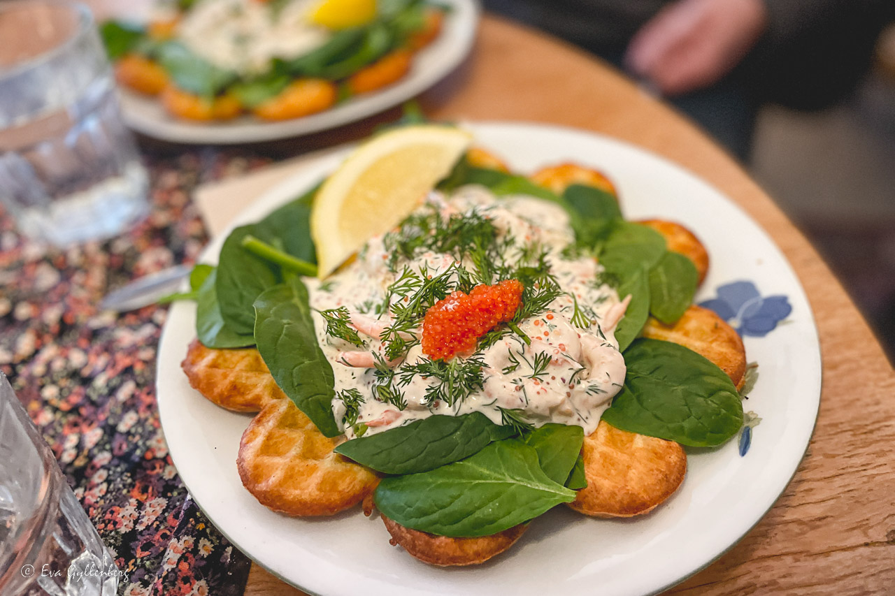 Våffla med räksallad och rom på en tallrik