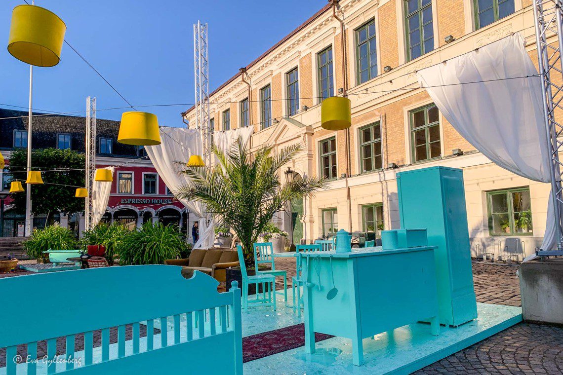 Square in Lund with turquoise furniture and yellow lamps