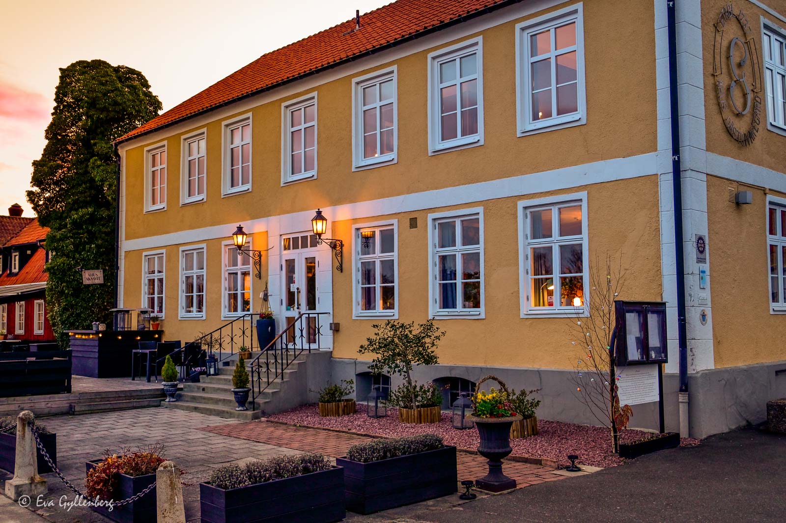ett gult herrgårdsliknande hus i solnedgång