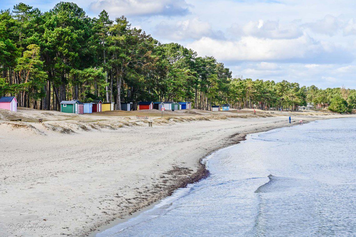 Små färgglada badstugor vid en vit strand