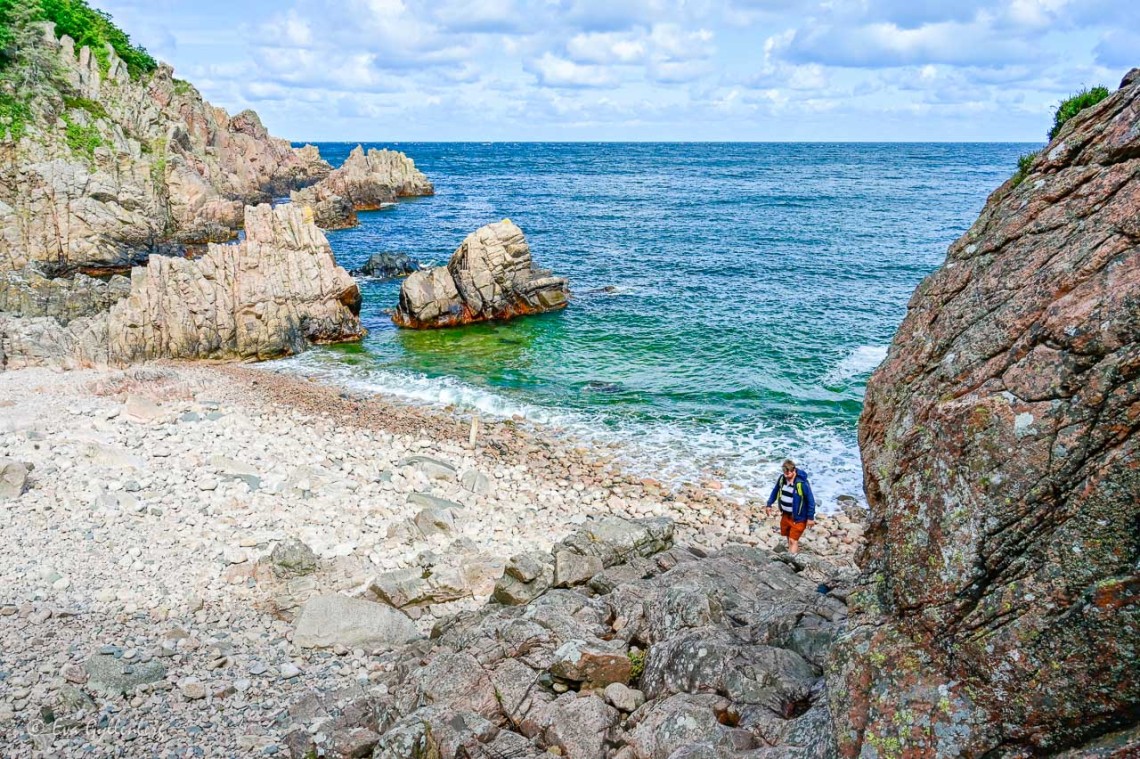 Stenig strand med blått hav
