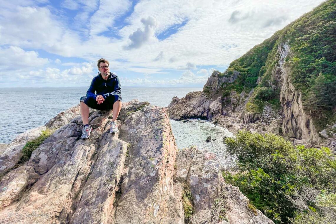 Man sitter på klippa högt över havet vid Skälderviken
