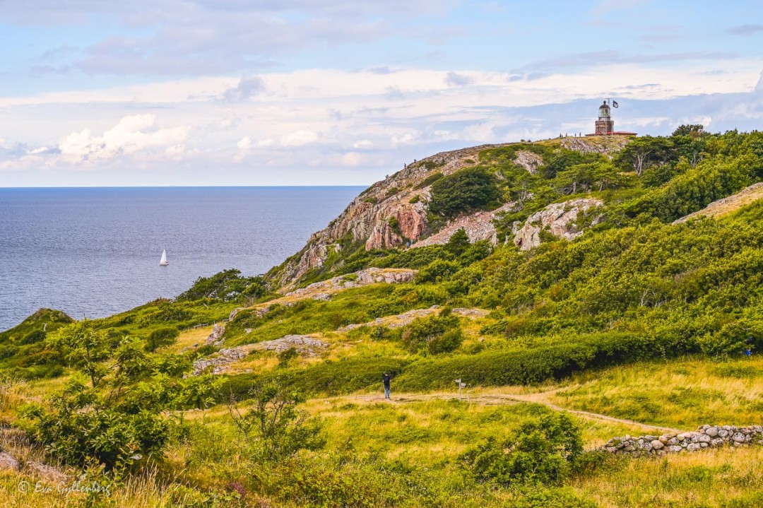Kullens fyr på en klippa på avstånd, med utsikt över havet ser du när du vandrar på Kullaleden.