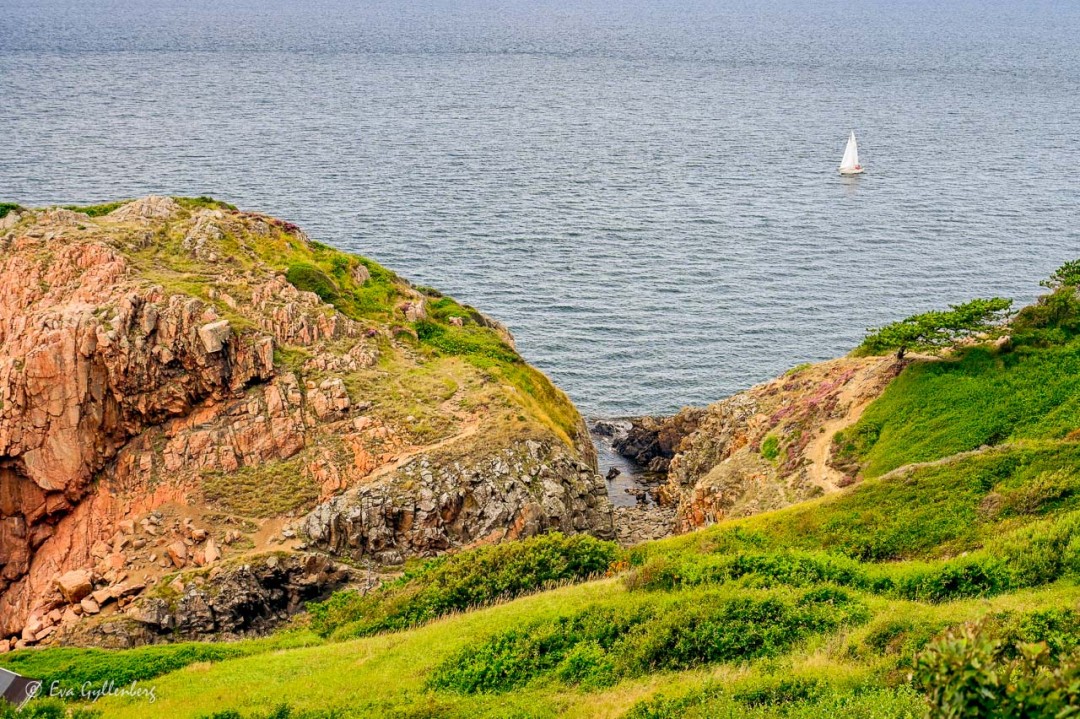Segelbåt på havet vid en klippig kust