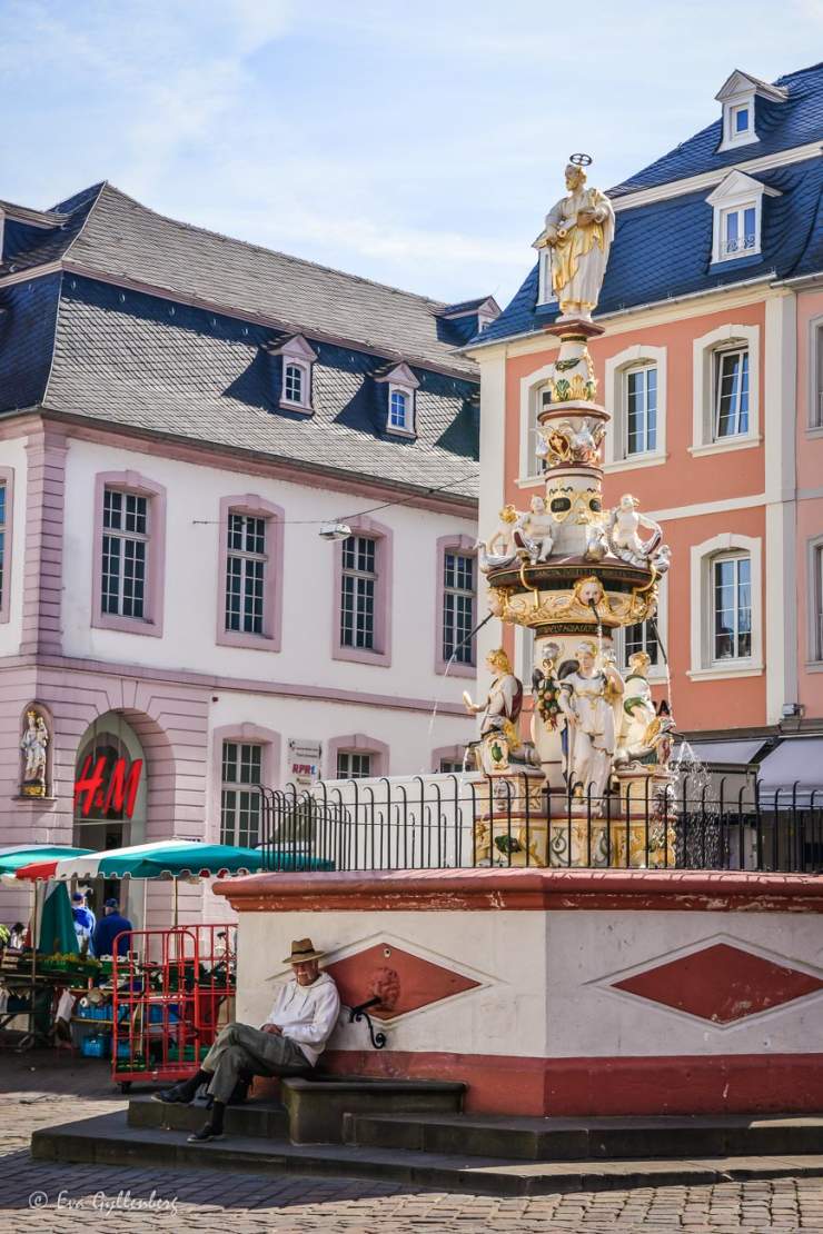 Man sittandes vid fontänen vid torget i Trier