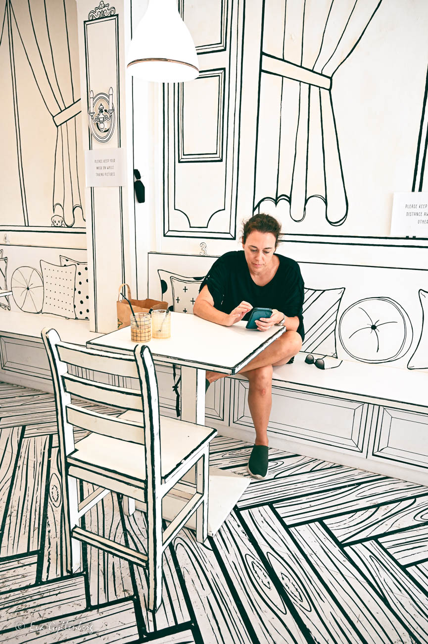 kvinna dricker en kaffe på ett 2D-café i svartvitt