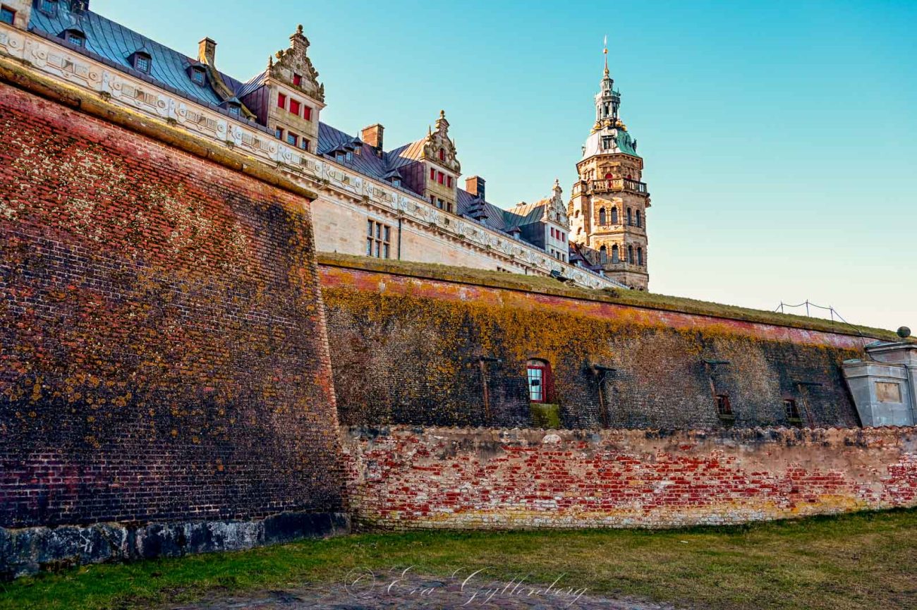 Kronborg slott i soluppgång bakom slottsmuren