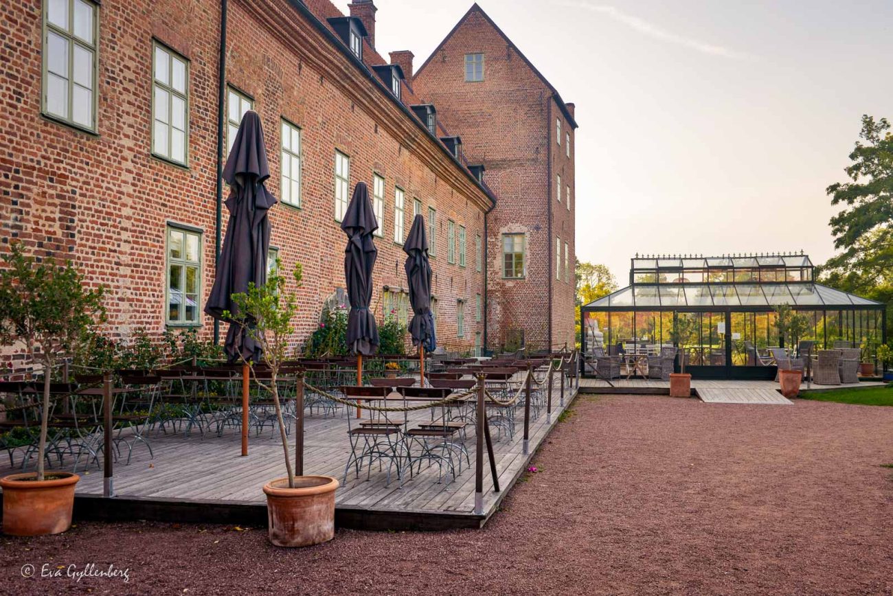 Restaurangen på Bäckaskog slotts uteservering med svarta parasoller