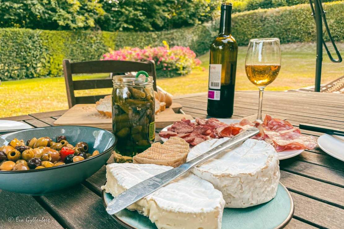 Mat och dryck i Normandie - Ostar, charkuterier, cornichoner och oliver på ett bord utomhus i Frankrike