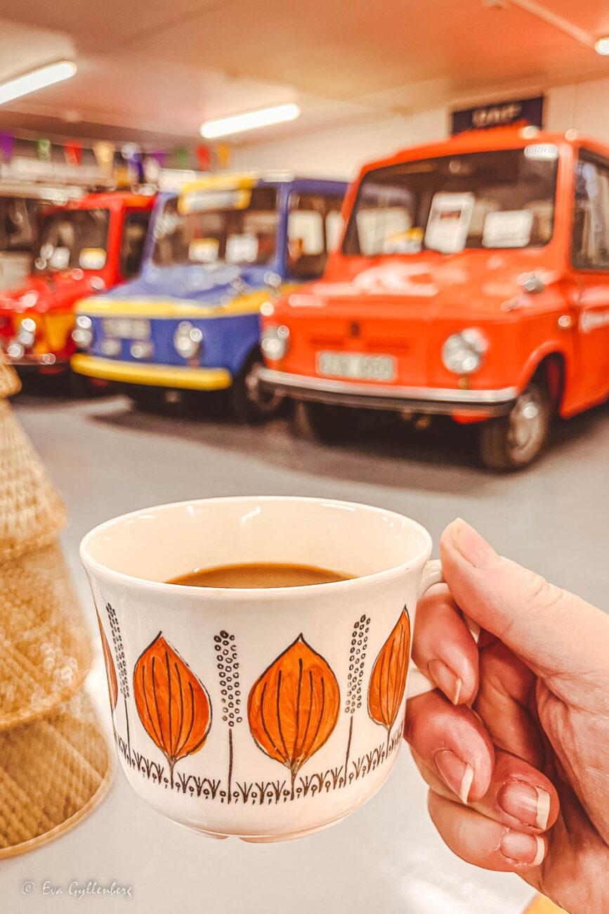 Tre tjorvenbilar på rad med en kopp kaffe i förgrunden av en fika i Kalmar