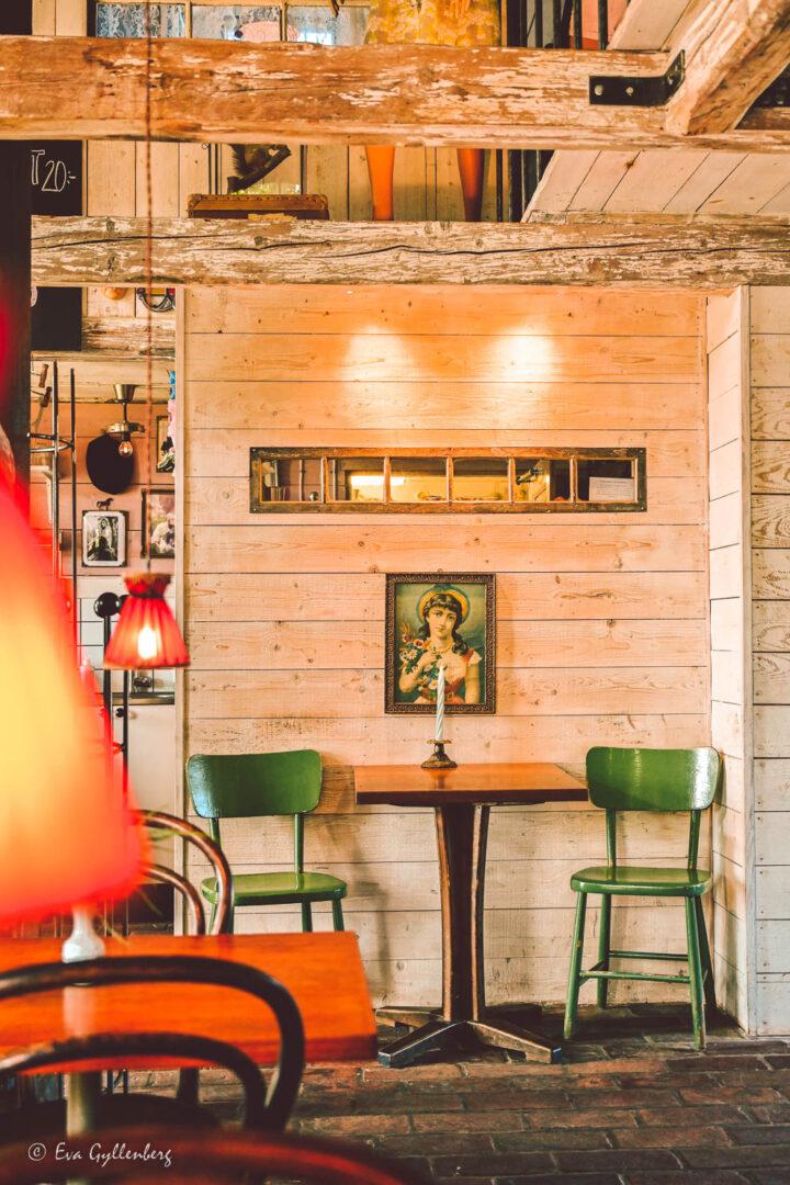 Lillaro cafe med två gröns stolar och en ikon