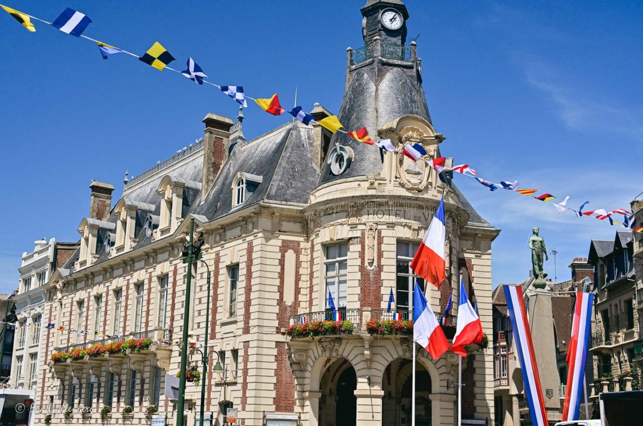 Flaggor hänger över en väg i Deauville med hus i bakgrunden