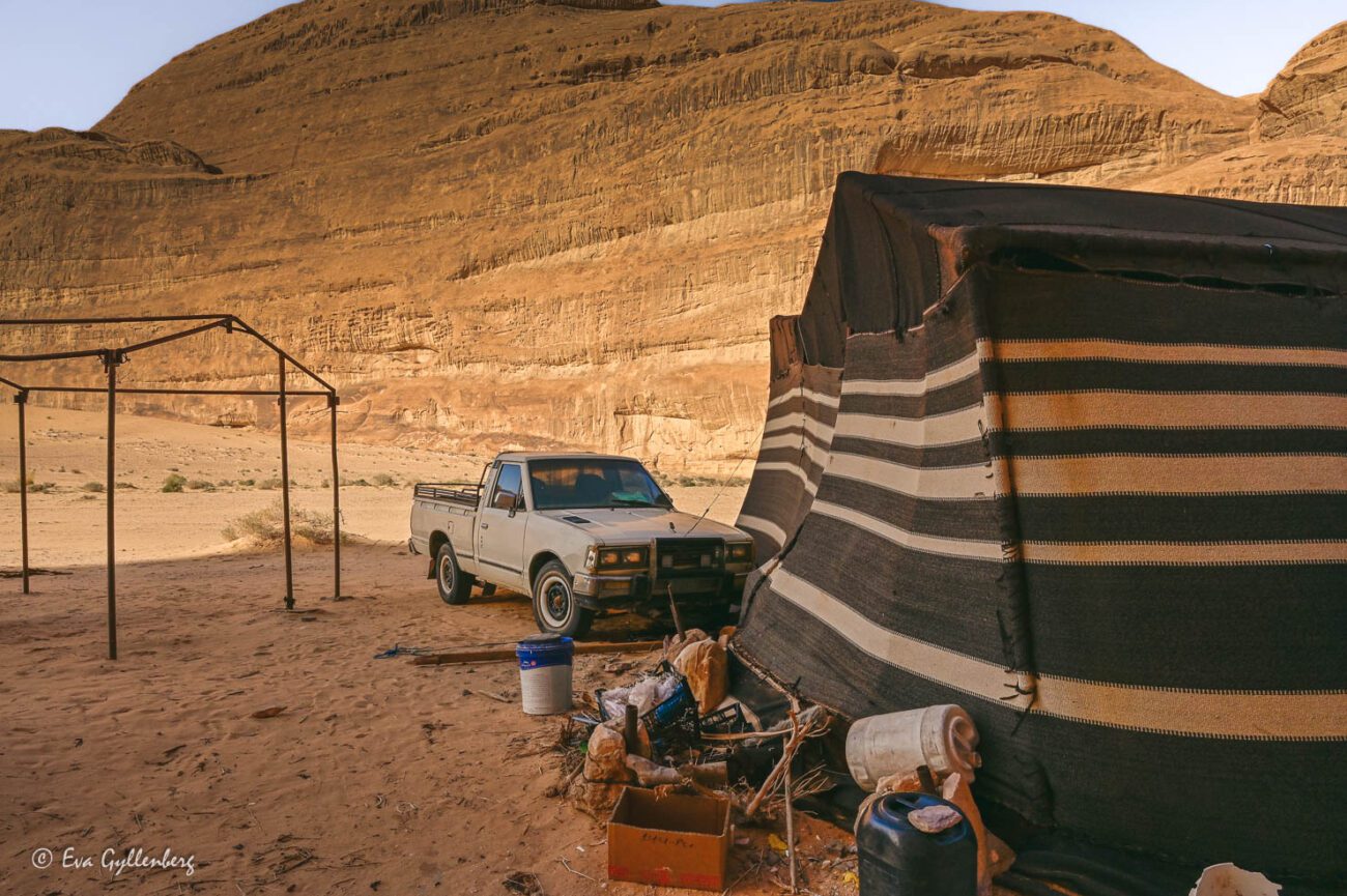 Bedouin tent in the shade in the desert with a white jeep