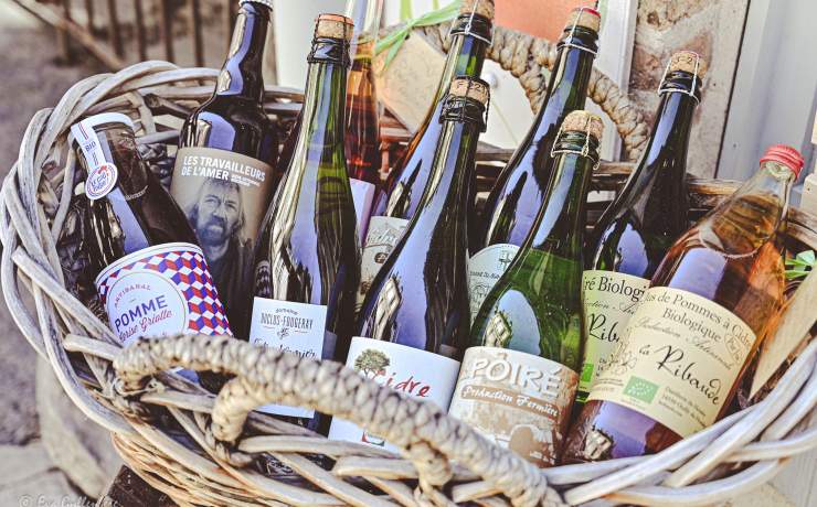 Flätad korg med flaskor av cider